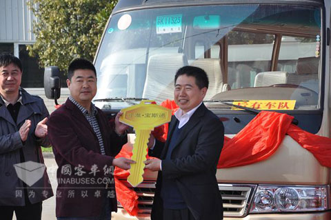 华山旅游汽车客运有限公司总经理刘新科(中间)接过江淮客车副总经理王泉龙金钥匙(右1)
