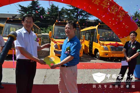 青岛交运集团党委副书记、常务副总王铃(左)与扬州亚星客车股份有限公司总经理吴永松交接钥匙