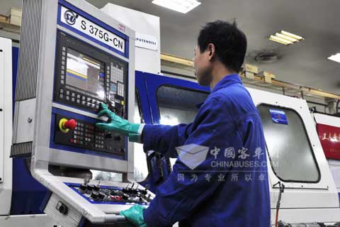 綦齿传动公司齿轮分厂一员工正在操作精密的磨齿设备
