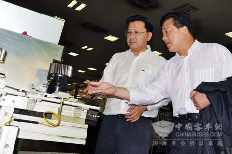 图为山东某交运集团客人（右一）在綦齿传动公司副总经理刘韶东的陪同下在现场了解綦齿变速器齿轮的精密加工工艺流程。